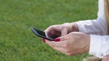 在公园里用智能手机<strong>触屏</strong>和使用app的女人的手特写